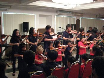 A group of violin players making music at our Kuala Belait recital