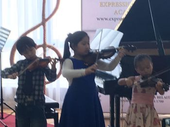 3 young children playing Violins during our Kuala Belait recital