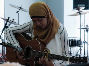 A lady makes music on a guitar